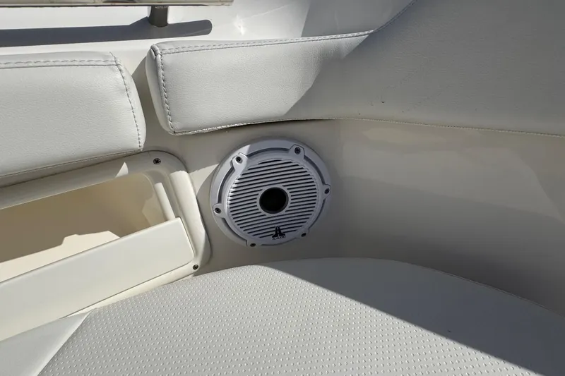 Slide: The Image of 2022 Pursuit DC 266 Dual Console boat interior with speaker and cushioned seating. - 78