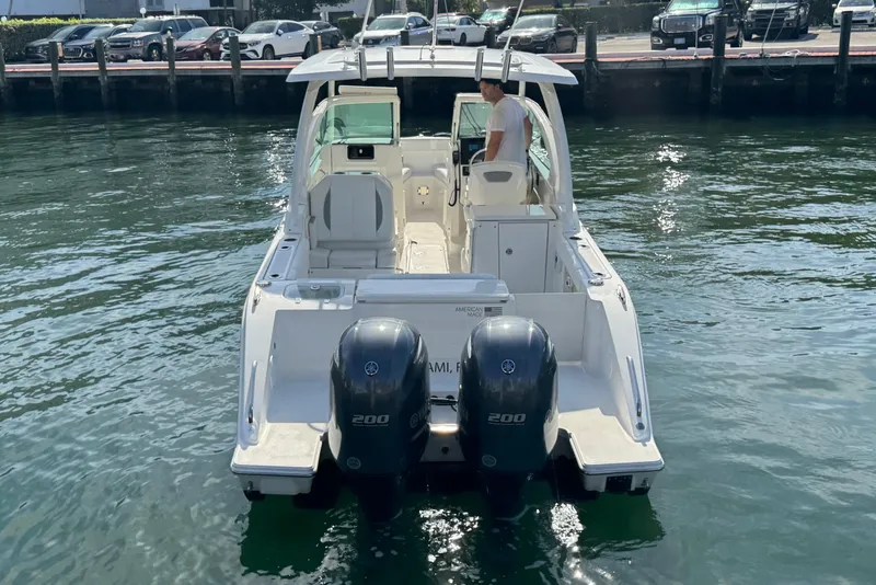 Slide: The Image of 2022 Pursuit DC 266 Dual Console boat on water, rear view with twin engines. - 8