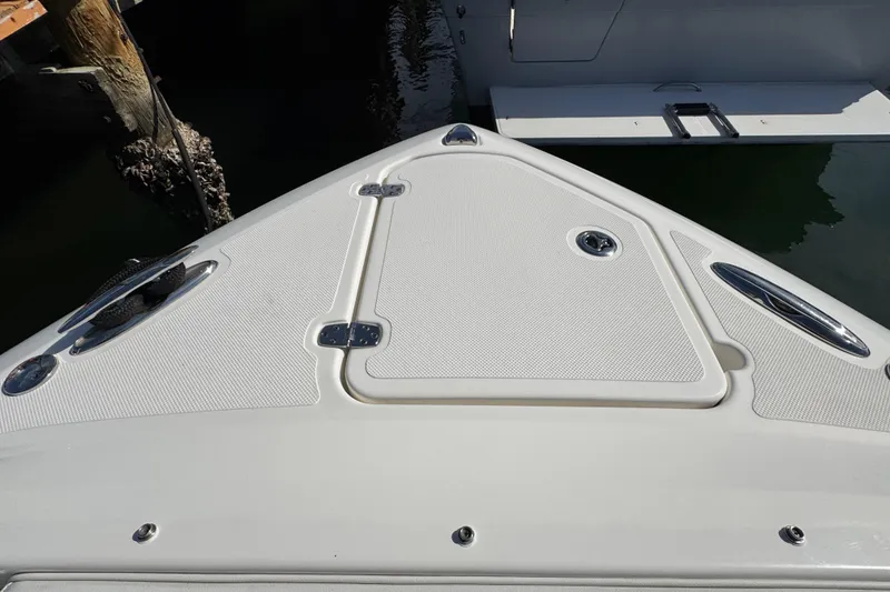 Slide: The Image of 2022 Pursuit DC 266 Dual Console boat deck with storage hatch and cleats. - 81