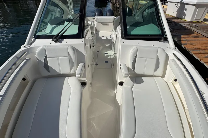 Slide: The Image of 2022 Pursuit DC 266 Dual Console boat interior with white seating and open deck. - 84