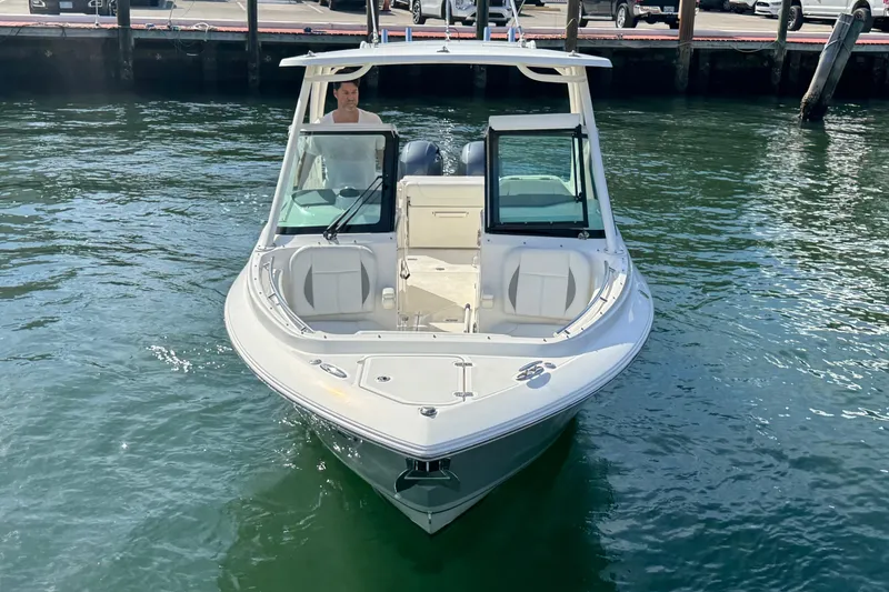 Slide: The Image of 2022 Pursuit DC 266 Dual Console boat on water near dock. - 9