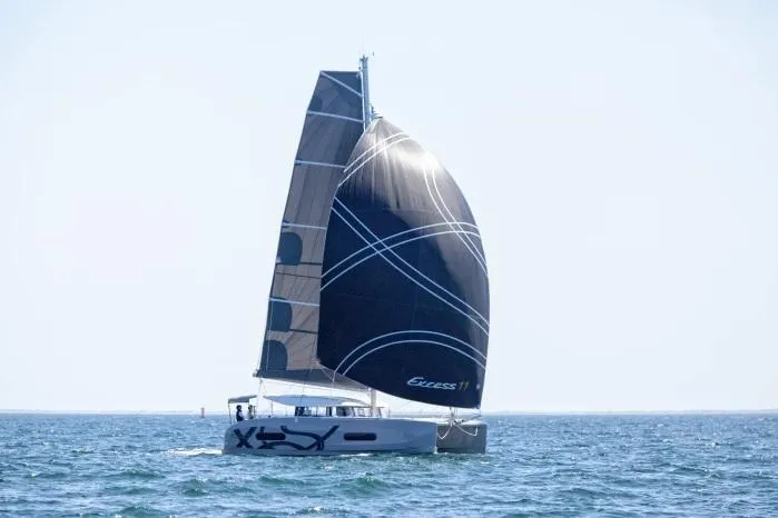 Slide: The Image of Manufacturer Provided Image: 2026 Excess 11 catamaran sailing on open sea with sleek black sails. - 12