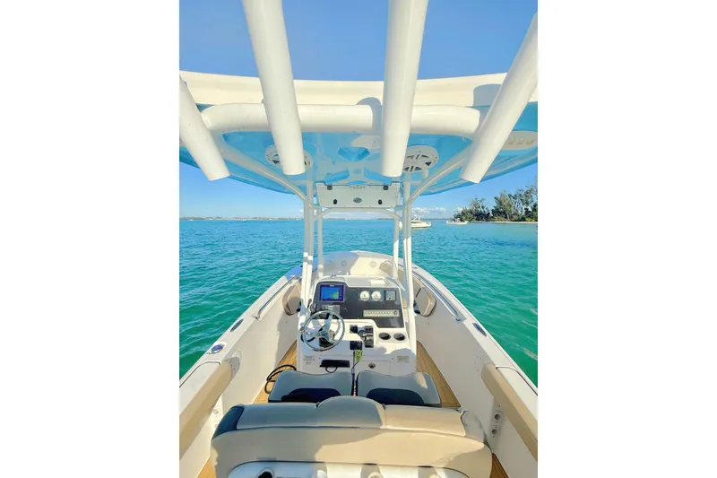 Slide: The Image of 2019 Tidewater 220 LXF boat interior with steering wheel, dashboard, and ocean view. - 4