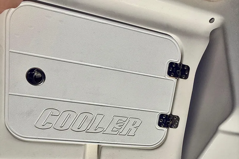 Slide: The Image of 2019 Tidewater 220 LXF boat cooler compartment with secure latch and hinges. - 7