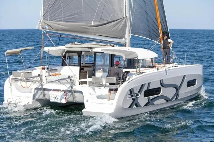 Slide: The Image of Manufacturer Provided Image: 2026 Excess 11 catamaran sailing on open sea with crew onboard. - 1