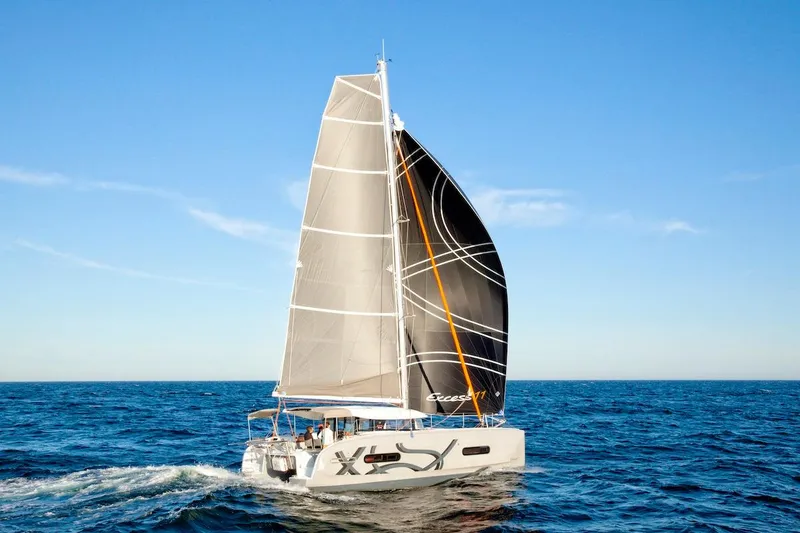 Slide: The Image of Sailing catamaran Excess 11, 2026 model, cruising on open sea under clear blue sky. - 31