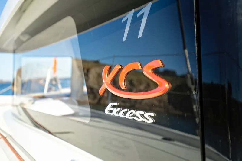 Slide: The Image of 2026 Excess 11 yacht logo on sleek black surface, reflecting sunlight. - 5