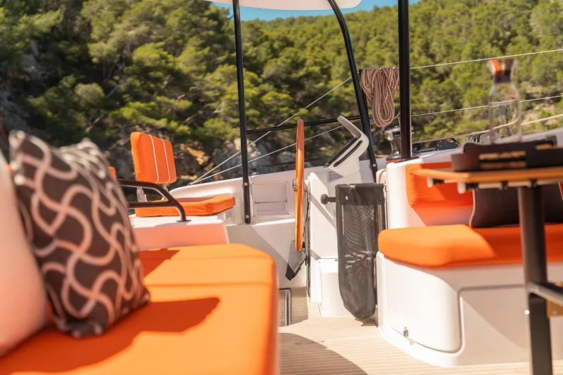 Slide: The Image of Luxurious 2026 Excess 13 yacht interior with vibrant orange seating and scenic forest backdrop. - 13