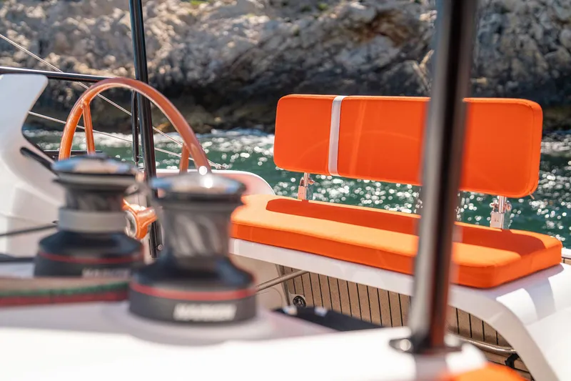 Slide: The Image of Luxurious 2026 Excess 13 yacht with vibrant orange seating, docked by rocky shoreline. - 17