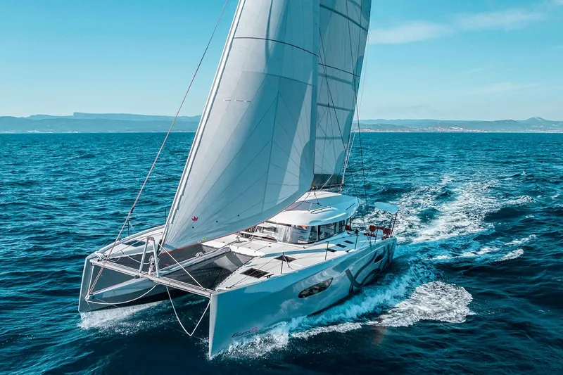 Slide: The Image of Manufacturer Provided Image: Sailing catamaran Excess 13, 2026 model, gliding on open sea under clear skies. - 7