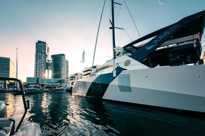 The Image of Aerial view of 2024 Wave Wave60 catamaran with solar panels on turquoise water. - 0