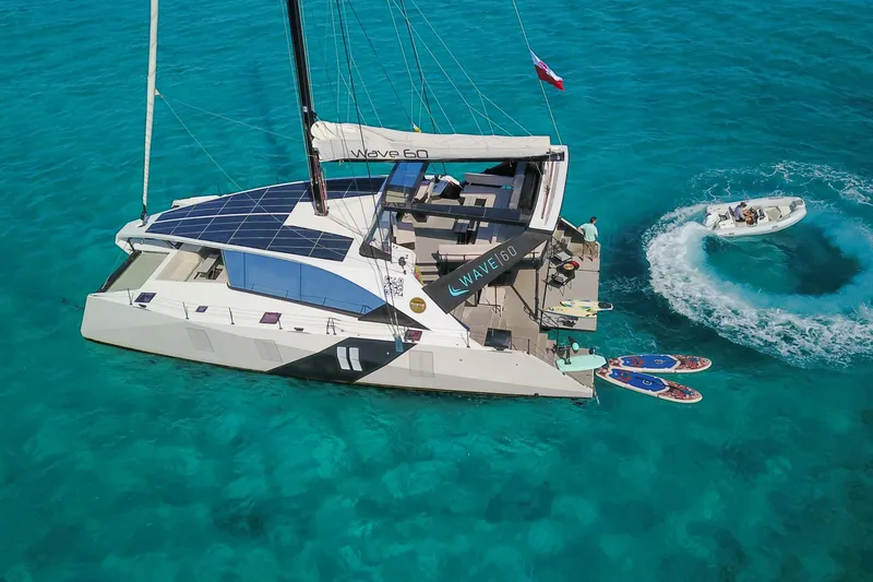Slide: The Image of 2024 Wave Wave60 catamaran sailing on open sea under clear blue sky. - 3