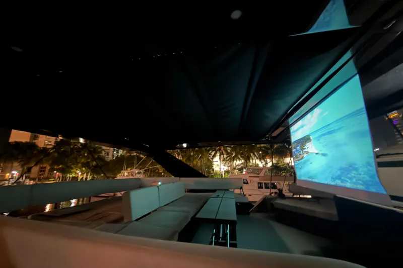 Slide: The Image of Luxurious 2024 Wave Wave60 yacht interior with outdoor seating and a large screen at night. - 32