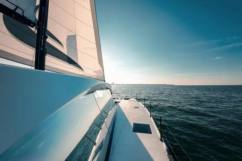 Slide: The Image of 2024 Wave Wave60 yacht deck with ocean view and person holding a drink. - 8