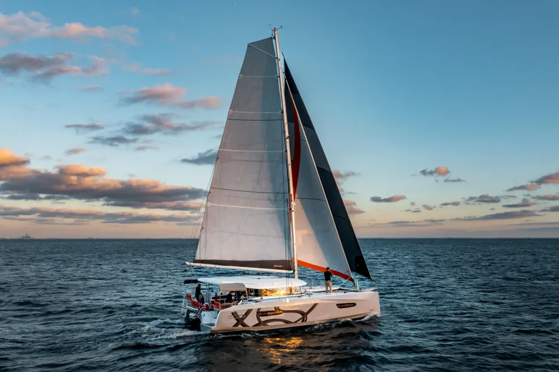 Slide: The Image of Sailing catamaran Excess 14, 2026 model, cruising at sunset on open sea. - 12