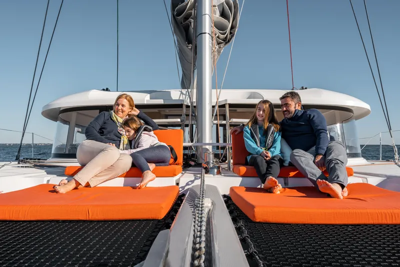 Slide: The Image of Family relaxing on 2026 Excess 14 catamaran, enjoying a sunny day at sea. - 13