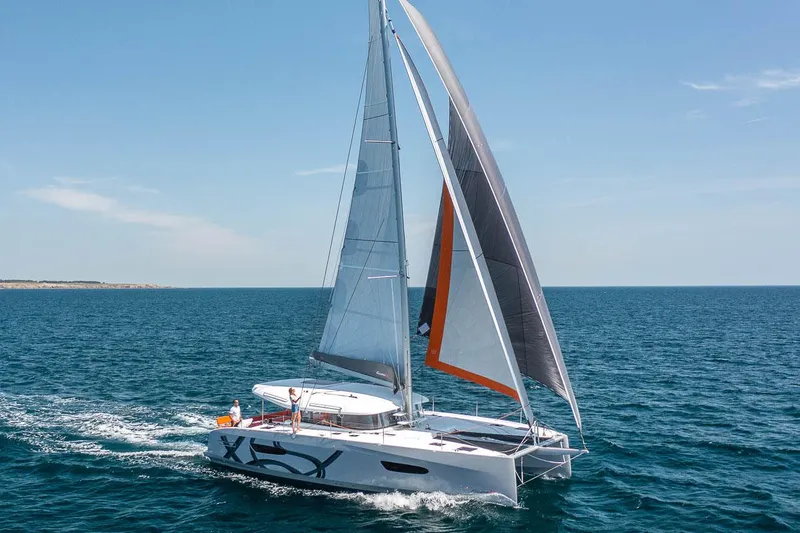 Slide: The Image of Manufacturer Provided Image: 2026 Excess 14 sailing catamaran cruising on open sea under clear blue sky. - 6
