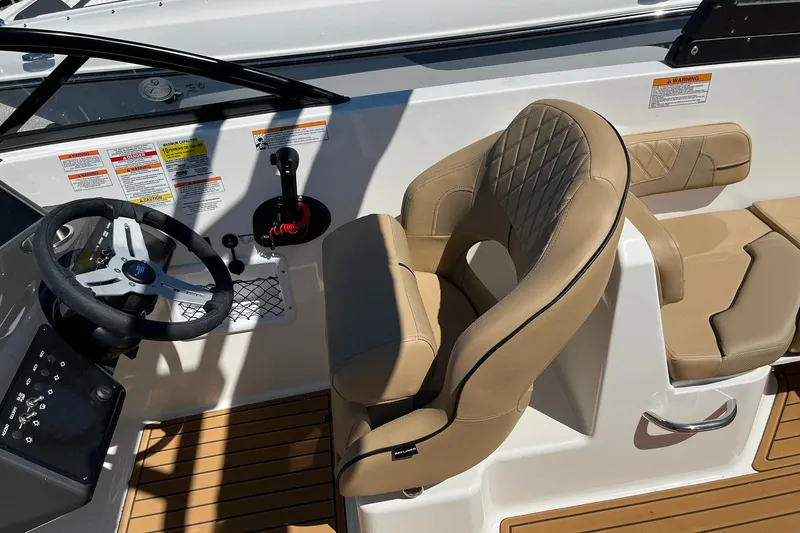 Slide: The Image of 2026 Bayliner VR6 Bowrider OB cockpit with tan seating and steering wheel. - 13