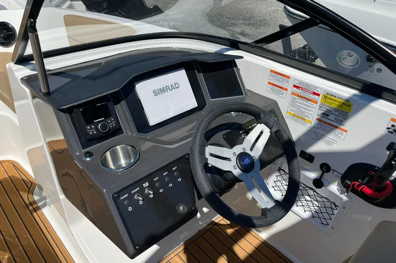 Slide: The Image of 2026 Bayliner VR6 Bowrider OB dashboard with steering wheel and Simrad display. - 14