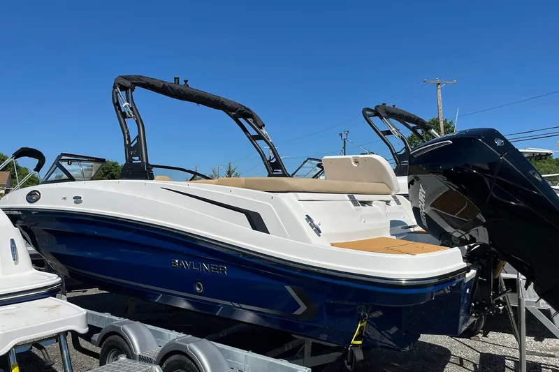 The Image of 2026 Bayliner VR6 Bowrider OB boat with sleek design on a trailer under clear blue sky. - 2