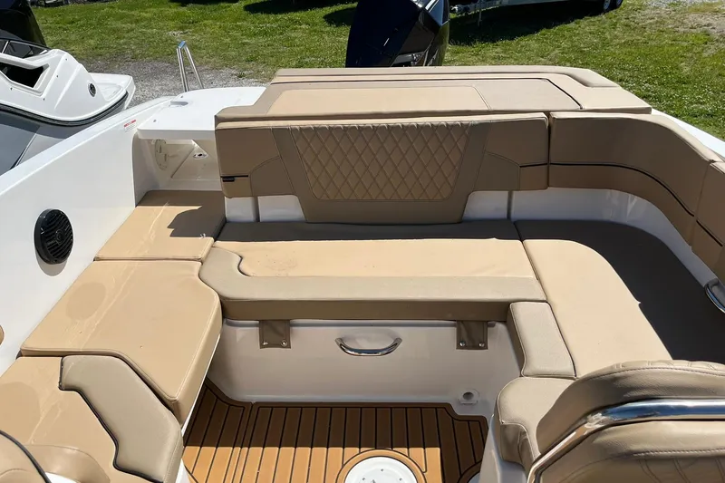 Slide: The Image of 2026 Bayliner VR6 Bowrider OB interior with tan seating and wood-style flooring. - 8