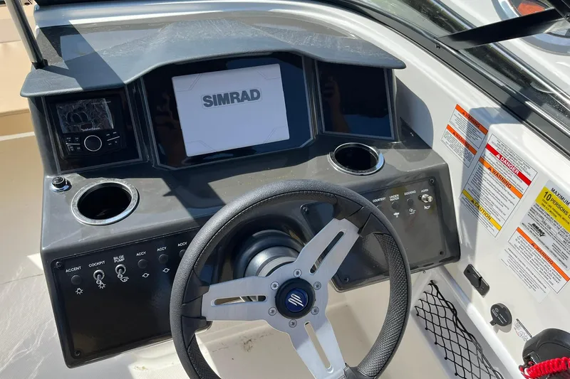 Slide: The Image of 2026 Bayliner VR6 Bowrider OB dashboard with steering wheel and Simrad display. - 17