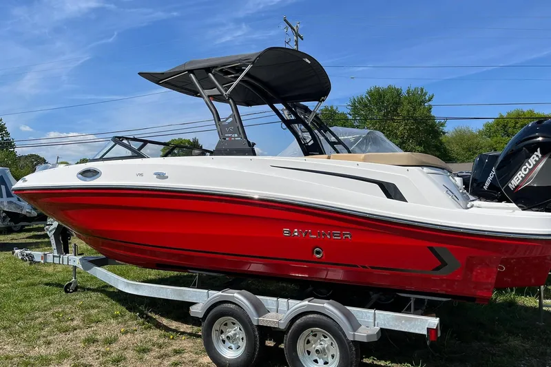 The Image of 2026 Bayliner VR6 Bowrider OB with red hull on trailer, parked outdoors. - 2