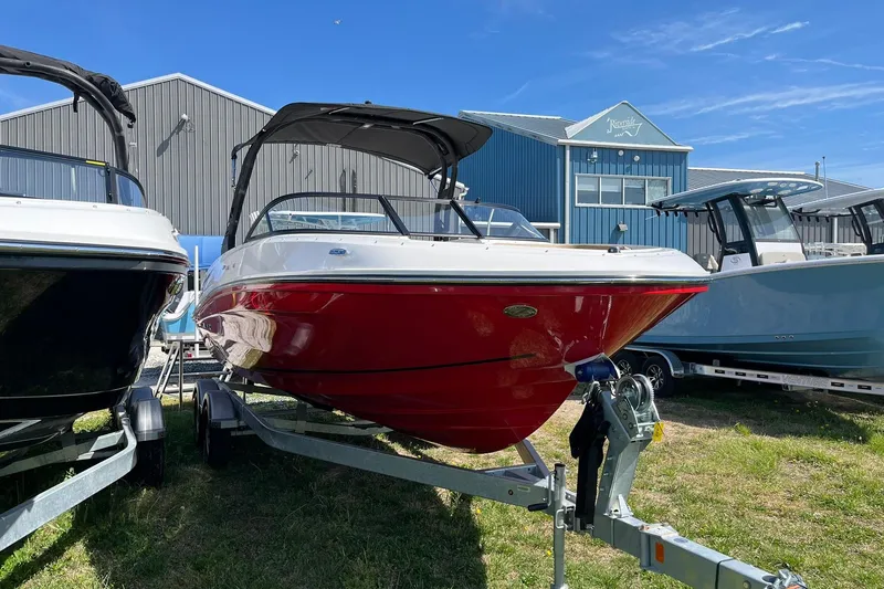 Slide: The Image of 2026 Bayliner VR6 Bowrider OB with red hull on trailer, displayed outdoors. - 5