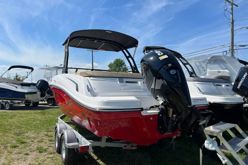 Slide: The Image of 2026 Bayliner VR6 Bowrider OB with outboard motor on trailer, under clear sky. - 6