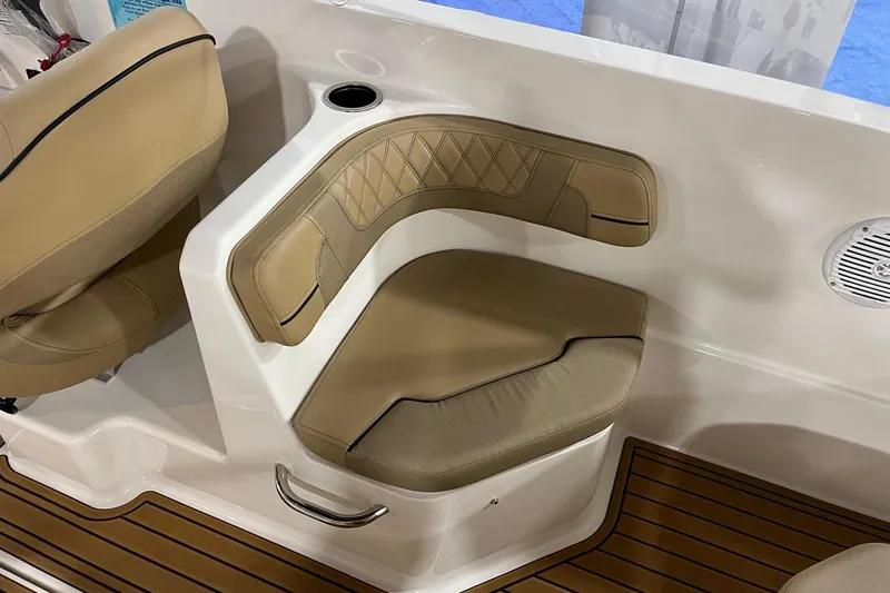 Slide: The Image of 2026 Bayliner VR6 Bowrider OB interior with tan seating and wood-style flooring. - 7