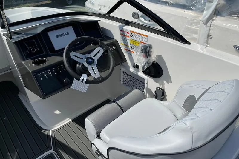 Slide: The Image of Interior view of 2026 Bayliner VR6 Bowrider OB, featuring steering wheel and dashboard controls. - 13