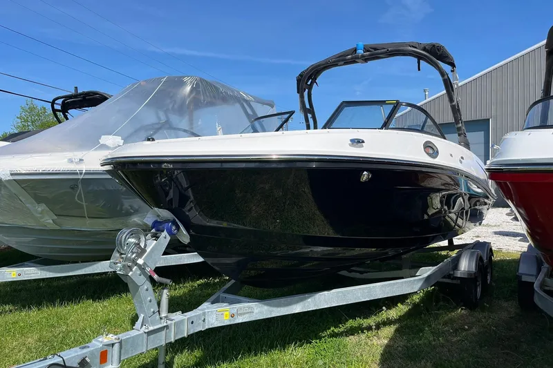 The Image of 2026 Bayliner VR6 Bowrider OB on trailer, displayed outdoors under clear blue sky. - 2