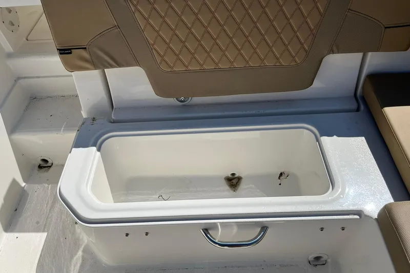 Slide: The Image of 2026 Bayliner VR6 Bowrider OB storage compartment with beige cushioned seating. - 10