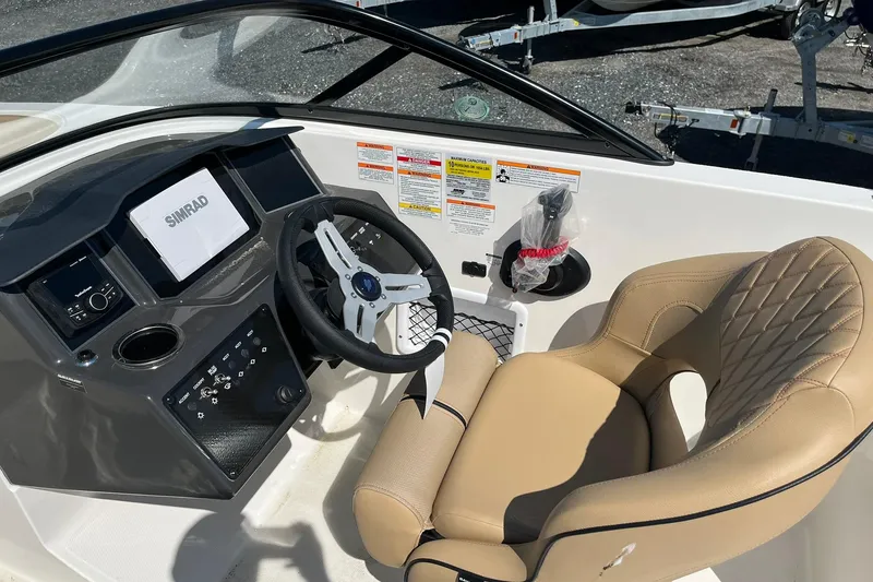 Slide: The Image of 2026 Bayliner VR6 Bowrider OB cockpit with steering wheel, Simrad display, and beige seating. - 15