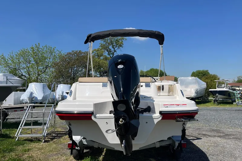Slide: The Image of 2026 Bayliner VR6 Bowrider OB with outboard motor, parked outdoors under clear blue sky. - 5