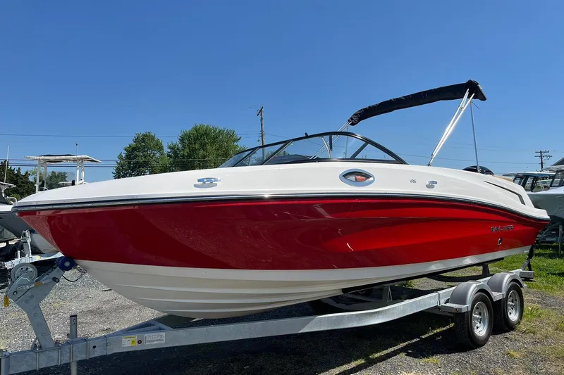 Slide: The Image of 2026 Bayliner VR6 Bowrider OB in red and white on a trailer, under clear blue sky. - 7