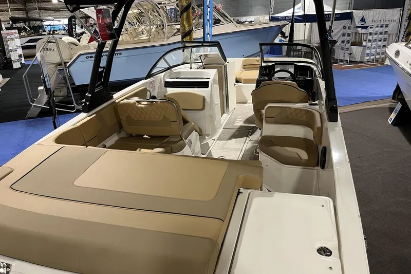 Slide: The Image of 2026 Bayliner VR6 Bowrider OB interior with tan seating at a boat show. - 4