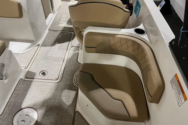 Slide: The Image of 2026 Bayliner VR6 Bowrider OB interior with beige seating and cup holder. - 7