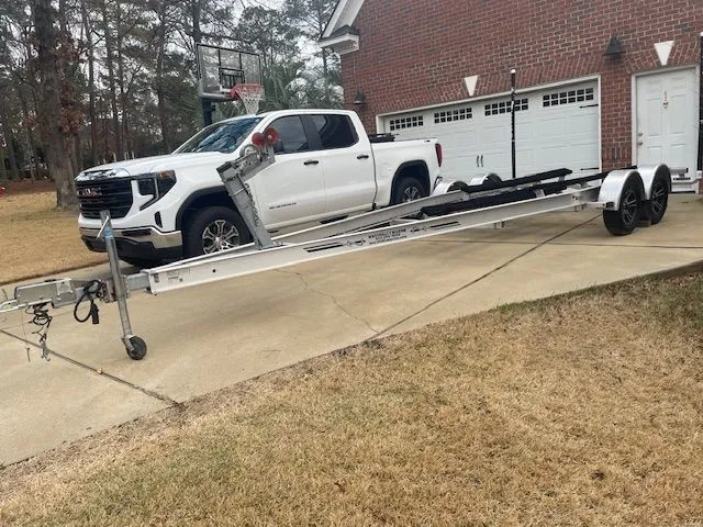 Slide: The Image of White pickup truck with boat trailer parked in front of brick house. - 31
