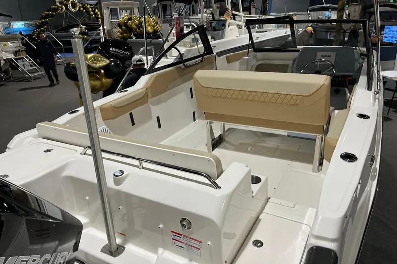 Slide: The Image of 2026 Bayliner Trophy T22SC boat interior with beige seating at a boat show. - 5