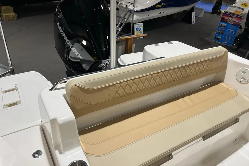 Slide: The Image of 2026 Bayliner Trophy T22SC boat interior with beige seating and Mercury engine. - 6