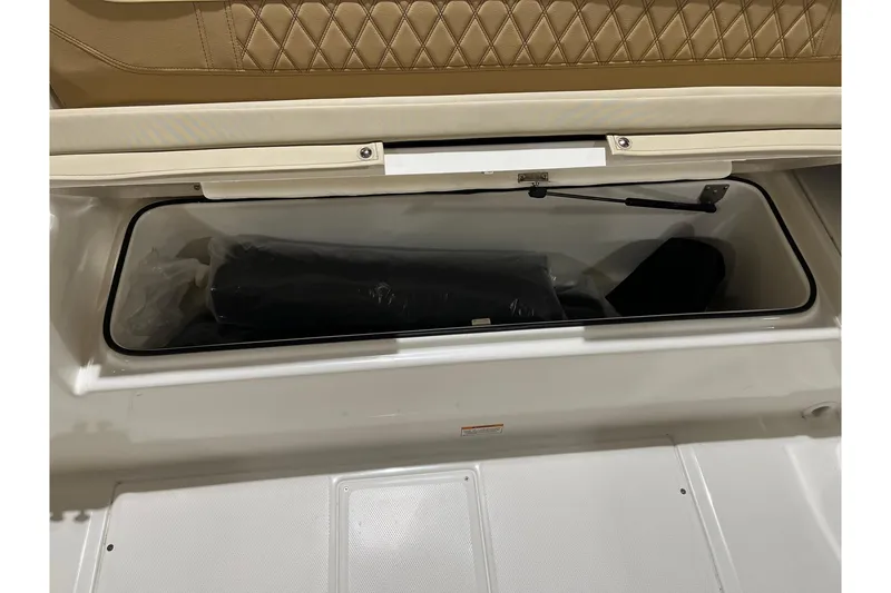 Slide: The Image of 2026 Bayliner Trophy T22SC storage compartment with cushioned seating and hydraulic lift. - 7