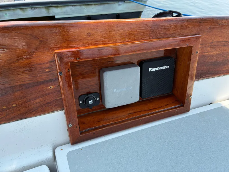 Slide: The Image of A wooden control panel on a boat with Raymarine equipment, docked by the water. - 31