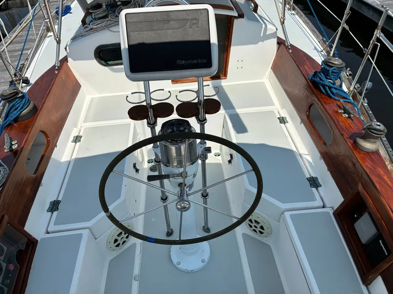 Slide: The Image of The cockpit of a 2001 Cape Dory Robinhood 36 with a steering wheel and navigation system. - 6