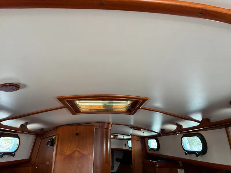 Slide: The Image of Interior of a 2001 Cape Dory Robinhood 36 with wood paneling and portholes. - 47