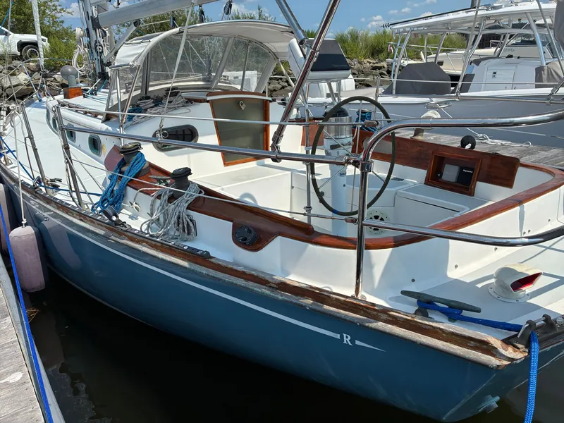 Slide: The Image of Cape Dory Robinhood 36 sailboat from 2001 with a blue hull and wooden cockpit details. - 2