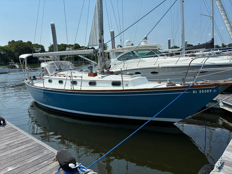 Slide: The Image of A 2001 Cape Dory Robinhood 36 docked. It features a blue hull and white superstructure. - 1