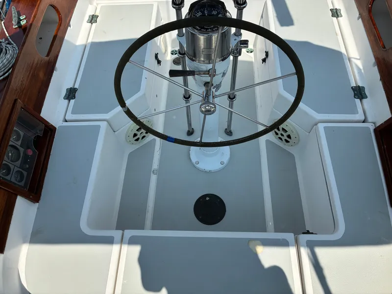 Slide: The Image of The cockpit of a 2001 Cape Dory Robinhood 36 with a steering wheel and wood accents. - 7