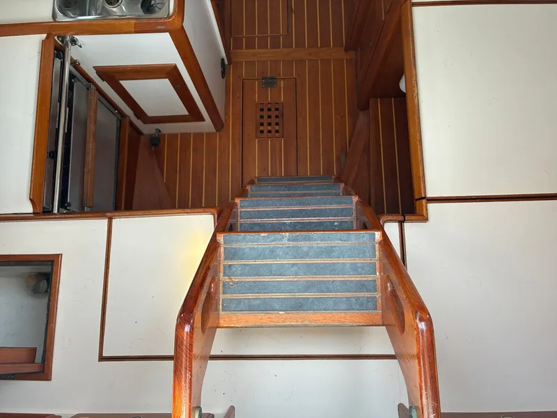 Slide: The Image of Interior of a 2001 Cape Dory Robinhood 36 with wooden stairs and flooring. - 34