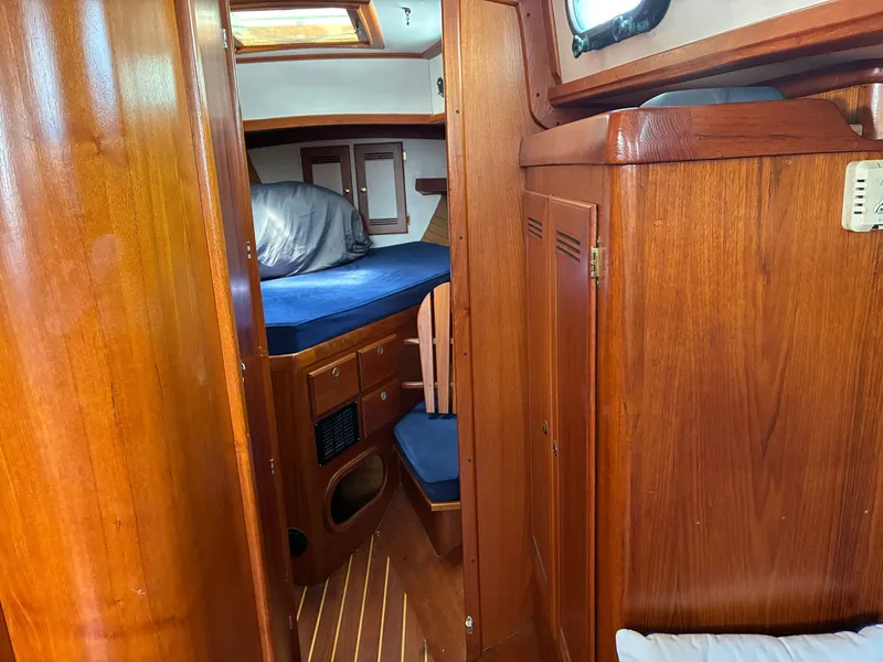 Slide: The Image of Interior of a 2001 Cape Dory Robinhood 36 with wood finish and blue cushions. - 49